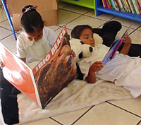 Children reading donated books.